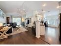 Bright open living room with hardwood floors, modern furniture, and large windows with access to a screened patio at 13850 Royston Bnd, Hudson, FL 34669