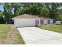 Inviting single-story home with a spacious driveway and attached garage at 1452 Haulover Ave, Spring Hill, FL 34608