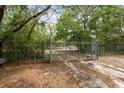 Metal gate with mature trees in background, provides security and entry to the property at 14740 Loma Ave, Spring Hill, FL 34610