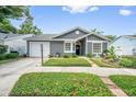Well-maintained one-story home with attached garage, manicured lawn and mature landscaping at 1486 Loman Ct, Palm Harbor, FL 34683