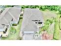 Birds-eye view of a well-maintained home with a neat roof, manicured yard, and lush surrounding greenery at 1723 Cortleigh Dr, Trinity, FL 34655
