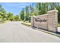 An elegant brick entrance with 'Wyndgate' sign, set against a backdrop of lush greenery and a clear blue sky at 1723 Cortleigh Dr, Trinity, FL 34655