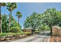 A secured community with brick pillars and an iron gate nestled among mature trees and manicured landscaping at 1723 Cortleigh Dr, Trinity, FL 34655