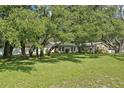 Single-story home with well-maintained lawn and mature trees creating a picturesque setting at 18633 Oak Way Dr, Hudson, FL 34667