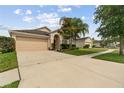 Traditional single-story home featuring a two-car garage, red door and green lawn at 18710 Dobson Dr, Hudson, FL 34667