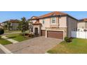 Charming two-story house features a tile roof, stone details, and a paved driveway at 19082 Umberland Pl, Land O Lakes, FL 34638