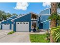 Charming two-story home with a blue exterior, front lawn, and attached one-car garage at 2026 Golfview Dr # 2026, Tarpon Springs, FL 34689