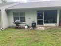 Back patio with a grill and screened-in porch, perfect for outdoor relaxation and entertaining at 2850 Westmoreland Ct, New Port Richey, FL 34655
