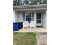 Inviting front porch with neutral colored paint and two comfortable wicker chairs at 2850 Westmoreland Ct, New Port Richey, FL 34655