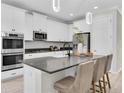 Modern kitchen with stainless steel appliances, a center island, and sleek white cabinetry at 3056 Abrams Trl, Odessa, FL 33556