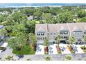 Aerial view of three-story townhome with lush landscaping and trees in a waterfront community at 3119 Oyster Bayou Way, Clearwater, FL 33759