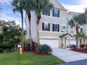 Charming three-story townhouse featuring a two-car garage, tropical landscaping, and a well-maintained lawn at 3119 Oyster Bayou Way, Clearwater, FL 33759