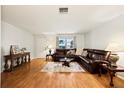 Spacious living room boasts hardwood floors, a leather sofa, and an abundance of natural light at 3534 Cockatoo Dr, New Port Richey, FL 34652