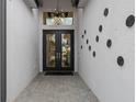Stylish entryway featuring double doors, stone pavers, and contemporary light fixture and unique decor at 3915 Corsica Pl, Wesley Chapel, FL 33543