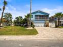 Charming two-story waterfront home with a paver driveway and a lush, tropical landscaped yard at 4128 Camelia Dr, Hernando Beach, FL 34607