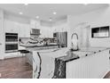 Modern kitchen with white cabinets, stainless steel appliances, and a marble island countertop at 4188 Barbour Trl, Odessa, FL 33556