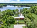 Stunning aerial view of lakeside estate featuring lush greenery, private dock, and inviting in-ground pool at 4541 School Rd, Land O Lakes, FL 34638
