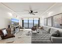 Bright living room featuring tile flooring, stylish furnishings, a ceiling fan, and expansive windows offering panoramic water views at 4550 Bay Blvd # 1231, Port Richey, FL 34668