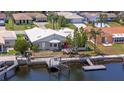 Waterfront home featuring a private boat dock with boat lift, patio, and red front door at 4918 Forecastle Dr, New Port Richey, FL 34652