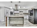 Modern kitchen features stainless steel appliances, a center island, and white cabinetry for a clean, contemporary design at 5113 Cedar Ln, Brooksville, FL 34601