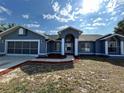 Single story home with a two-car garage and a decorative columned entrance. and landscaped front yard at 5294 Elkin Ave, Spring Hill, FL 34606