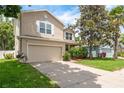 Charming two-story home featuring a well-manicured lawn and a two-car garage at 6125 Desert Peace Ave, Land O Lakes, FL 34639