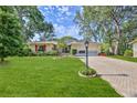 Inviting single-story home with manicured lawn, red shutters, and paved driveway leading to the attached garage at 6172 Prestwick Ct, Spring Hill, FL 34606