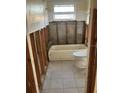 Bathroom requiring renovation, showing exposed wall studs, updated shower with new tile, and new toilet at 6205 Westport Dr, Port Richey, FL 34668