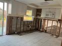 Kitchen needing renovation featuring white cabinets, tile floors, exposed wall studs, and natural light at 6205 Westport Dr, Port Richey, FL 34668