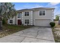 Two-story home with a red front door, large windows, a palm tree, and a two car garage at 6440 Curtiss Ln, Spring Hill, FL 34609