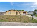 Quaint one-story home with a stucco finish, attached garage, and manicured lawn on a sunny day at 7035 Cutty Sark Dr, Port Richey, FL 34668
