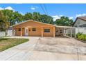 Single-story home showcasing its neutral exterior, long driveway, and covered carport at 713 715 W Fribley St, Tampa, FL 33603