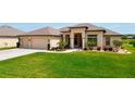 Well manicured green lawn in front of a well maintained home with a brick paver driveway and attached garage at 9125 Palm Beach Dr, Brooksville, FL 34613