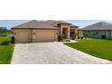 Charming curb appeal featuring an inviting front yard with stone paver driveway and attached two car garage at 9125 Palm Beach Dr, Brooksville, FL 34613