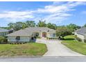 Charming single-story home with a well-manicured lawn, mature trees, and a double-door entrance at 9216 Tarleton Cir, Weeki Wachee, FL 34613