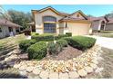 A charming single Gathering home with a manicured front yard with decorative rocks and lush bushes at 9311 Haas Dr, Hudson, FL 34669