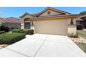 A well-maintained two car garage is connected by a clean driveway and manicured front yard at 9311 Haas Dr, Hudson, FL 34669