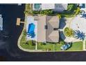 Aerial view of waterfront home featuring a private pool, dock, and lush landscaping at 9930 San Diego Way, Port Richey, FL 34668