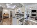 A charming kitchen featuring white cabinets, granite countertops, a breakfast bar, stainless steel appliances, and hardwood floors at 10910 Winter Oak Pl, Tampa, FL 33618