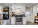 Kitchen area showcasing stainless steel appliances, granite countertops, white cabinets, and an exterior door at 10910 Winter Oak Pl, Tampa, FL 33618