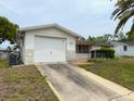 Charming single-story home featuring an attached garage, white exterior, and covered entry at 11224 Yewtree Ave, Port Richey, FL 34668