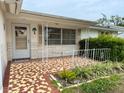 Inviting front porch featuring tile flooring, decorative railings, and a colorful palm tree decal at 11224 Yewtree Ave, Port Richey, FL 34668