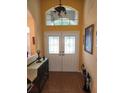 Inviting foyer with a tiled floor, decorative double doors, and a transom window letting in natural light at 12270 Clarendon Ct, Spring Hill, FL 34609