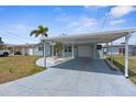 This home features a covered carport with a spacious driveway and a well-kept yard at 13411 Lisa Dr, Hudson, FL 34667