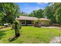 Expansive backyard with a screened-in porch, wood deck, and lush greenery at 14145 Citrus Way, Brooksville, FL 34601