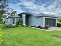 Well-maintained single-story house with a manicured lawn and a two-car garage at 18109 Webster Grove Dr, Hudson, FL 34667