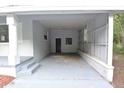 Spacious covered carport with concrete floor and access door, freshly painted in neutral tones at 18838 Rosephil St, Spring Hill, FL 34610