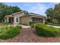Charming home boasts mature landscaping, neutral exterior, and an attached two-car garage at 261 Rochester St, Spring Hill, FL 34609