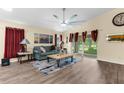 A stylish living room featuring hard floors, a ceiling fan, and sliding glass doors at 261 Rochester St, Spring Hill, FL 34609
