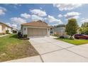 Single-story home showcasing an attached two-car garage, extended driveway, and a well-kept lawn at 284 Quane Ave, Spring Hill, FL 34609